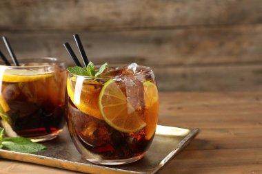 Küba libre kokteylini ahşap masada nane şekeriyle tazeliyorum. Metin için boşluk