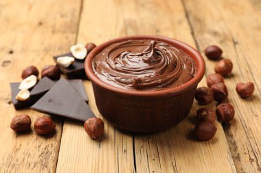 Lezzetli fındık ezmesi, çikolata parçaları ve fındıklar ahşap masada, yakın plan.