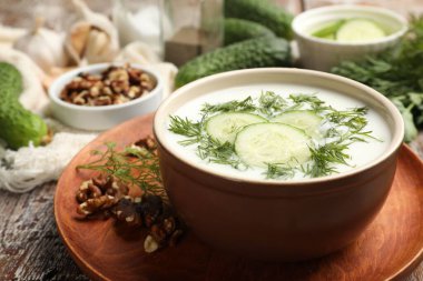 Ahşap masada dereotu ve fındıklı lezzetli salatalık çorbası, yakın plan.