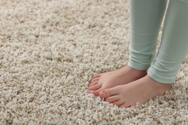 Evdeki yumuşak halıdaki kız, yakın plan. Metin için boşluk