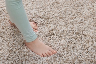 Evdeki yumuşak halıdaki kız, yakın plan. Metin için boşluk