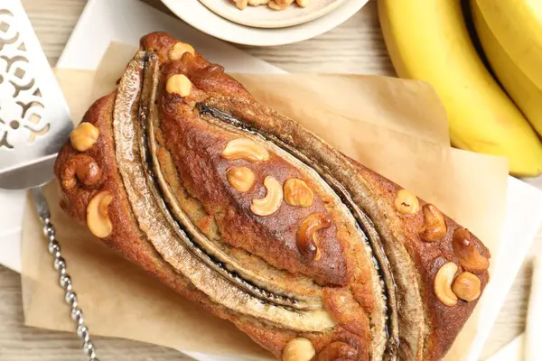 Fındıklı, meyveli ve ahşap masadaki sunuculu nefis ev yapımı muz ekmeği.