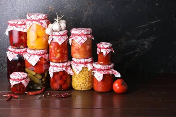 Birçok kavanoz farklı turşu ürünleri ve malzemeler ahşap masa üzerinde, metin için yer