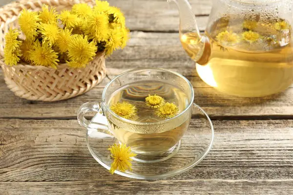 Tazeleyici karahindiba çayı ve çiçekler ahşap masada, yakın plan