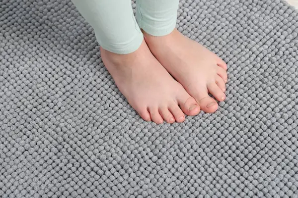 Evdeki yumuşak halıdaki kız, manzaranın üstünde.