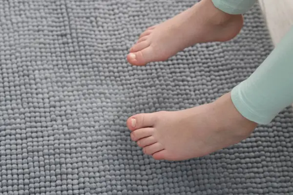 Evdeki yumuşak halının üstündeki kız, yakın plan. Metin için boşluk