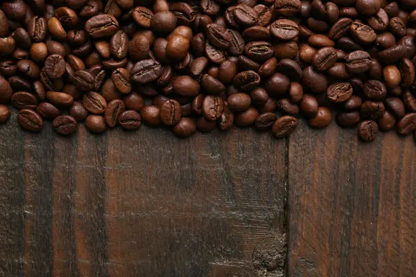 Aromatik kahve çekirdekleri, ahşap masa, üst manzara. Metin için boşluk