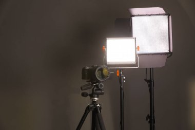 Profesyonel ışıklandırma ekipmanı ve gri arka planda kamera. Metin için boşluk