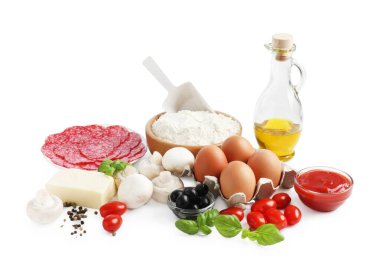 Pizza yapıyorum. Farklı malzemeler beyaza izole edilmiş.