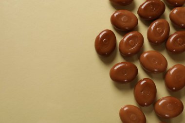 Bej arka planda bir sürü lezzetli karamel şekeri, düzlük. Metin için boşluk