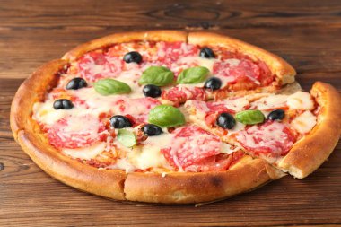 Salamlı, peynirli, fesleğenli ve zeytinli lezzetli pizza.