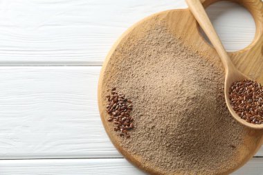 Keten tohumu unu ve kaşıkla beyaz ahşap masa, üst manzara. Metin için boşluk