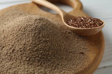 Keten tohumu unu ve kaşıkla masada tohum, yakın plan.