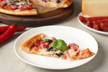 Hafif masada servis edilen ince tütsülenmiş sosisli, lezzetli bir pizza.