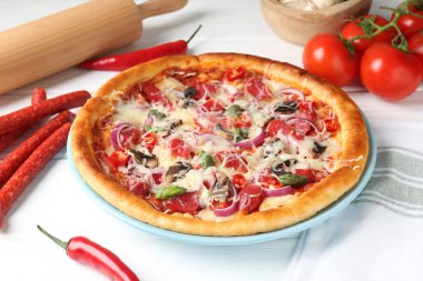 İnce tütsülenmiş sosis ve malzemelerle dolu leziz bir pizza, yakın plan.