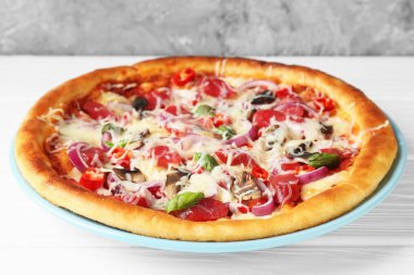 Beyaz ahşap masada ince füme sosisli lezzetli pizza, yakın plan.