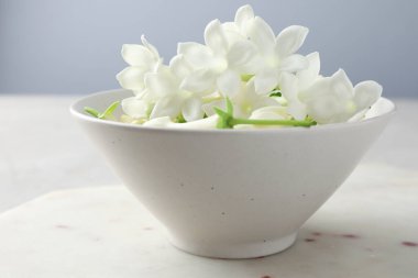 Güzel yasemin çiçekleri masada kasede, yakın plan