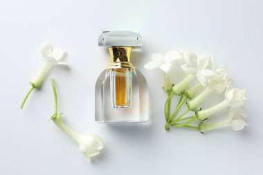 Beyaz arka planda parfüm ve yasemin çiçekleri, düz yatıyordu.