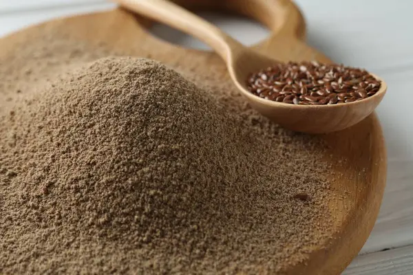 Keten tohumu unu ve kaşıkla masada tohum, yakın plan.