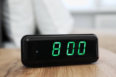 Dijital alarm saat 8 'de kapalı bir masada.