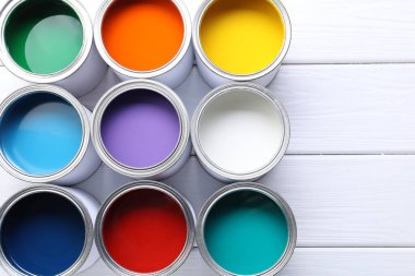 Beyaz ahşap masa üzerinde parlak boya kutuları, düz yatıyordu. Metin için boşluk