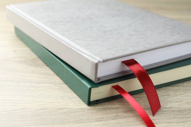 Açık ahşap masa üzerinde kırmızı kurdele yer imleri olan kitaplar, yakın plan