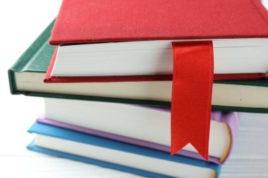 Kırmızı kurdele yer imi ve beyaz ahşap masada renkli olanlar, yakın plan.