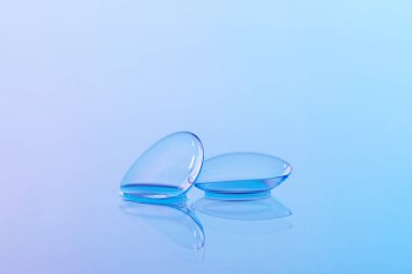 Kontakt lensler ve su damlaları mavi ayna yüzeyine, yakın plan.