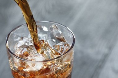 Tazeleyici kolayı bulanık gri arka planda cama döküyorum. Yakın plan. Metin için boşluk