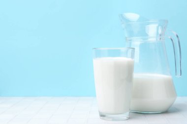 Açık mavi arka planda beyaz masada taze süt. Metin için boşluk