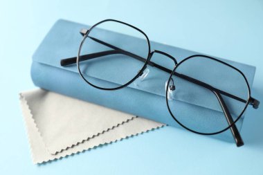 Açık mavi arka planda şık gözlüklü ve temiz giysili çanta, yakın plan