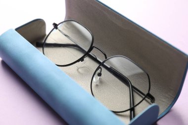 Mor arka planda şık gözlüklü çanta, yakın plan