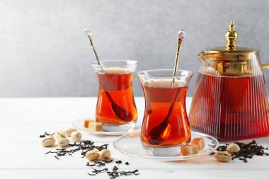 Beyaz ahşap masada lezzetli Türk çayı, şeker ve şam fıstığı. Metin için boşluk
