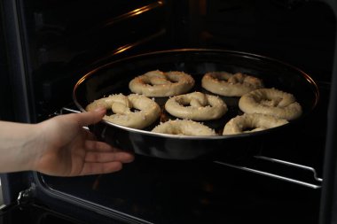 Pişmemiş krakerlerle fırına yemek koyan kadın, yakın plan.