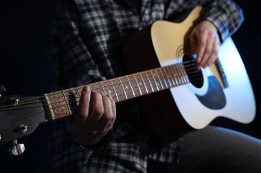 Siyah arka planda gitar çalan kadın, yakın plan
