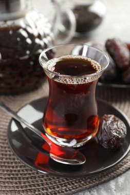 Geleneksel cam fincanda Türk çayı ve masaya tarihler, yakın plan