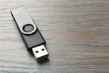 Tahta arka planda bir flaş bellek, yakın plan. Metin için boşluk