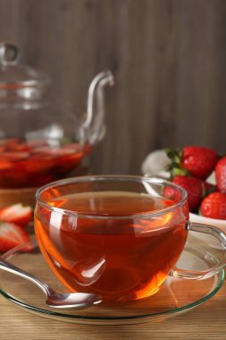 Ahşap masadaki çilekli Aromatik meyve çayı, yakın plan.