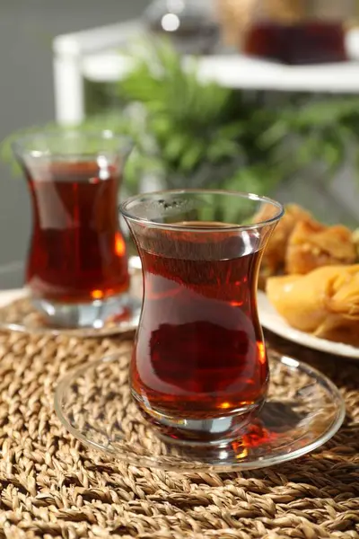 Geleneksel cam bardaklarda Türk çayı ve masada taze baklava, yakın plan.