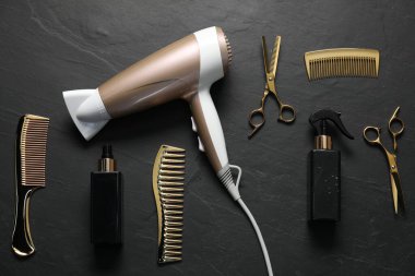 Siyah desenli arka planda farklı saç şekillendirme araçları, düz yatış