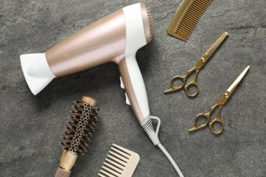 Gri dokulu arka planda farklı saç şekillendirme araçları, düz yatış