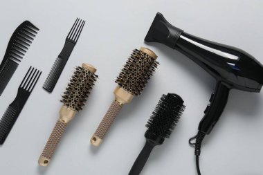 Beyaz arka planda farklı saç şekillendirme araçları, düz yatış