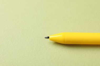 Yeşil arka planda şık bir kalem, yakın plan. Metin için boşluk