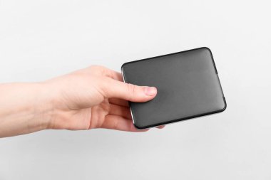 Açık gri arkaplanda harici sabit diski olan adam, yakın plan.