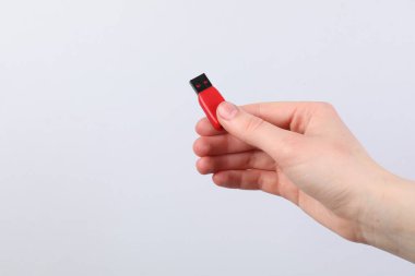 Açık gri arka planda modern flash diski olan adam, yakın plan. Metin için boşluk