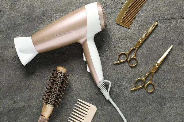 Gri dokulu arka planda farklı saç şekillendirme araçları, düz yatış