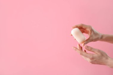 Açık pembe arka planda sabun çubuğu olan kadın, yakın plan. Metin için boşluk