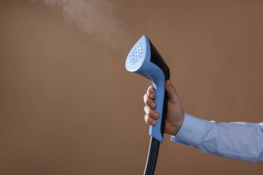 Kahverengi arka planda vapuru olan adam, yakın plan. Metin için boşluk