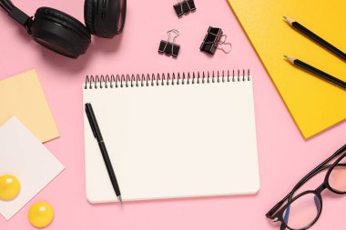 Pembe zemin üzerinde planlayıcı ve kırtasiye malzemesi, düz uzanma