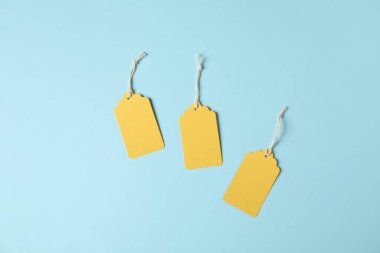 Açık mavi arkaplanda dizgileri olan boş etiketler, düz yatıyordu